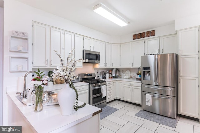 kitchen with white cabinetry and appliances with stainless steel finishes