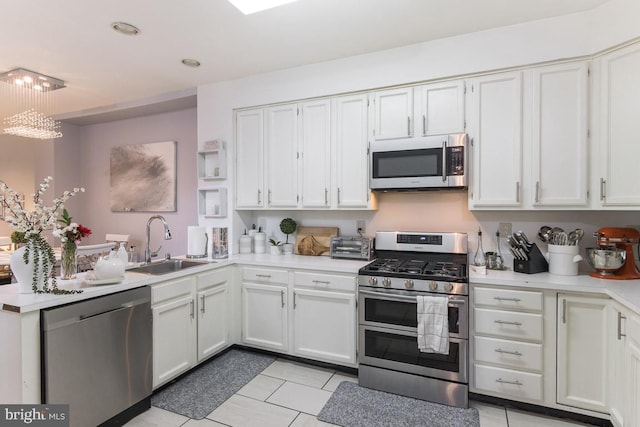 kitchen with white cabinets, light tile patterned floors, sink, and appliances with stainless steel finishes