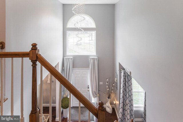 stairway with a towering ceiling and a notable chandelier