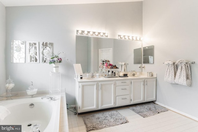 bathroom featuring tile patterned flooring, vanity, and tiled bath