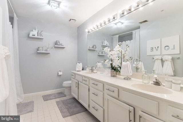 bathroom featuring tile patterned floors, vanity, and toilet