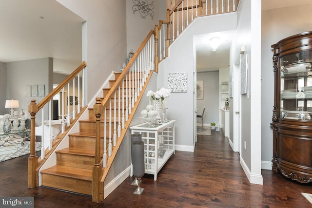 stairs with a high ceiling and hardwood / wood-style flooring