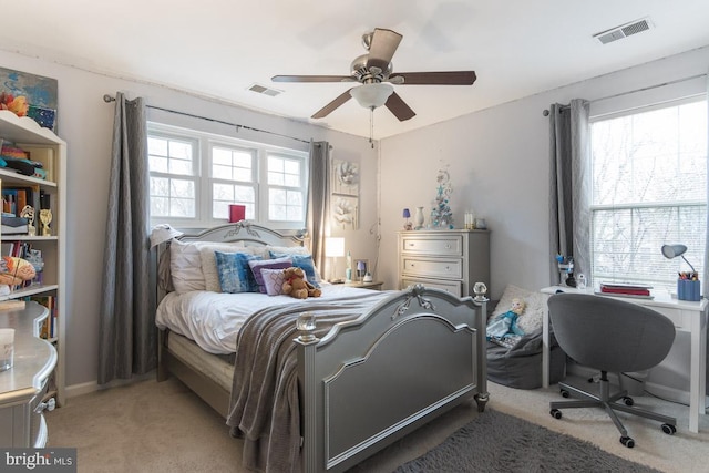 carpeted bedroom featuring ceiling fan and multiple windows