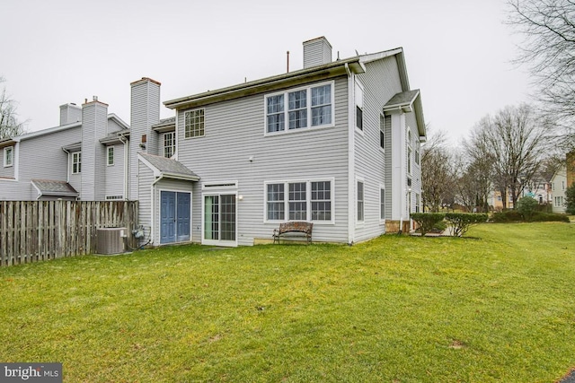 back of house featuring a lawn and central AC unit