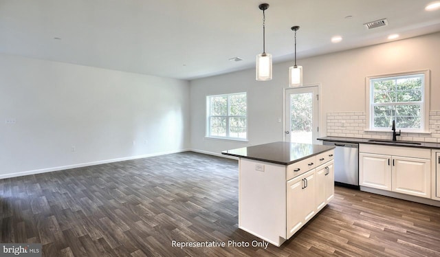 kitchen featuring white cabinetry, sink, hanging light fixtures, stainless steel dishwasher, and dark hardwood / wood-style floors