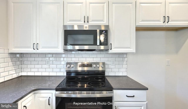 kitchen with tasteful backsplash, white cabinetry, dark stone counters, and stainless steel appliances