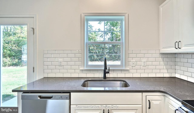 kitchen with stainless steel dishwasher, plenty of natural light, white cabinetry, and sink