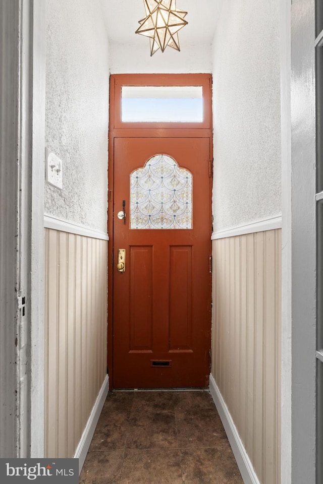 doorway featuring wooden walls