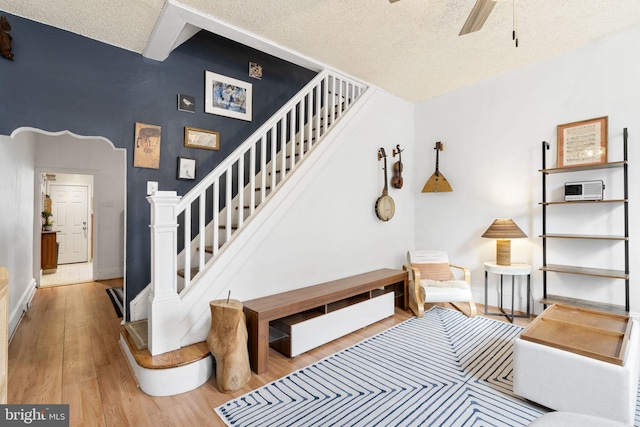 stairway featuring hardwood / wood-style floors, a textured ceiling, and ceiling fan