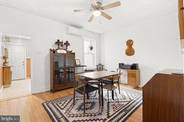 dining room with ceiling fan, a textured ceiling, a wall unit AC, and light hardwood / wood-style floors