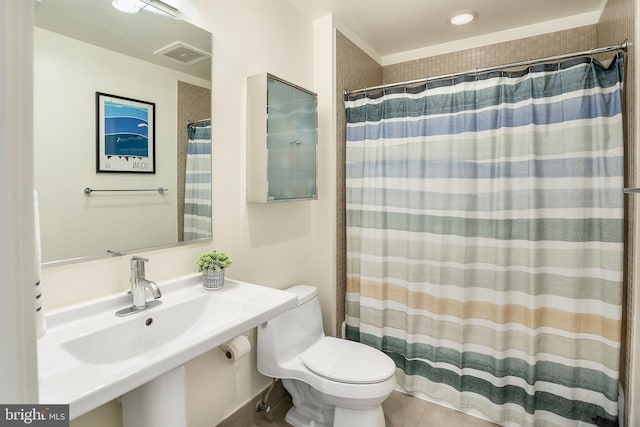 bathroom with visible vents, toilet, a shower with curtain, tile patterned flooring, and a sink