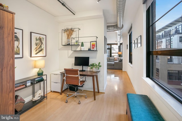 office area with light wood finished floors and baseboards