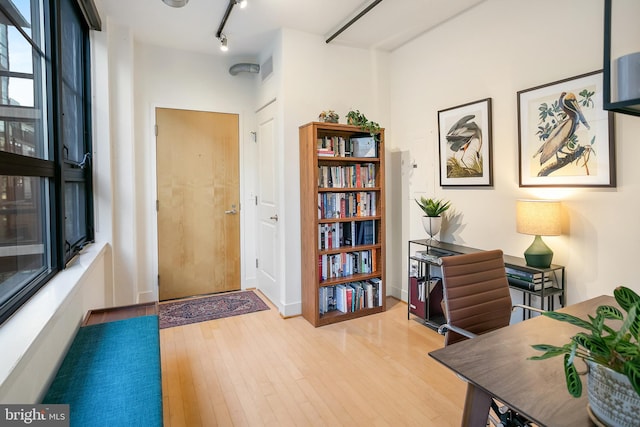 office space with track lighting, visible vents, and light wood finished floors