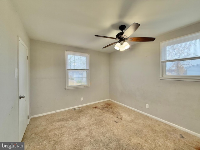 carpeted spare room featuring ceiling fan