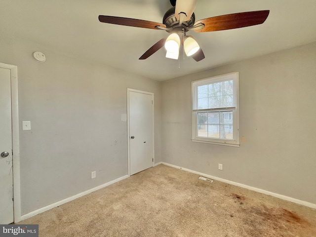 carpeted spare room with ceiling fan