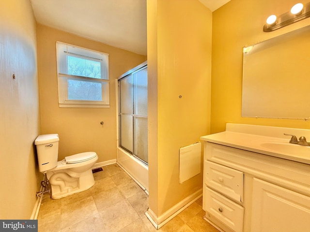 full bathroom featuring toilet, vanity, and shower / bath combination with glass door