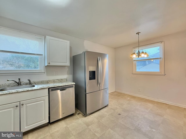 kitchen featuring a chandelier, appliances with stainless steel finishes, hanging light fixtures, sink, and white cabinetry