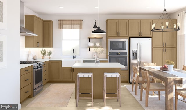 kitchen featuring appliances with stainless steel finishes, hanging light fixtures, wall chimney exhaust hood, and sink