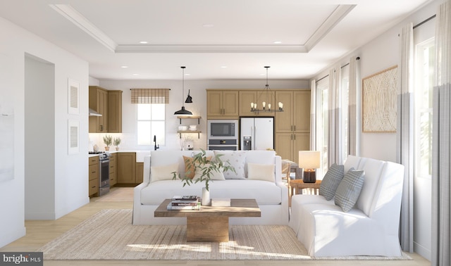 living room featuring light hardwood / wood-style floors, a raised ceiling, sink, and a chandelier