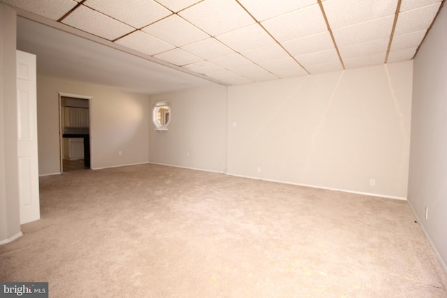 interior space with a paneled ceiling and light colored carpet