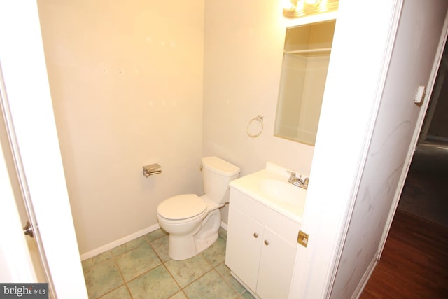 bathroom with toilet, vanity, and tile patterned floors