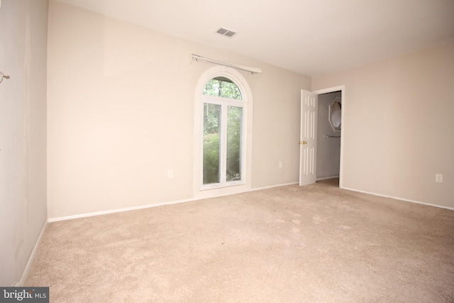 spare room featuring light colored carpet