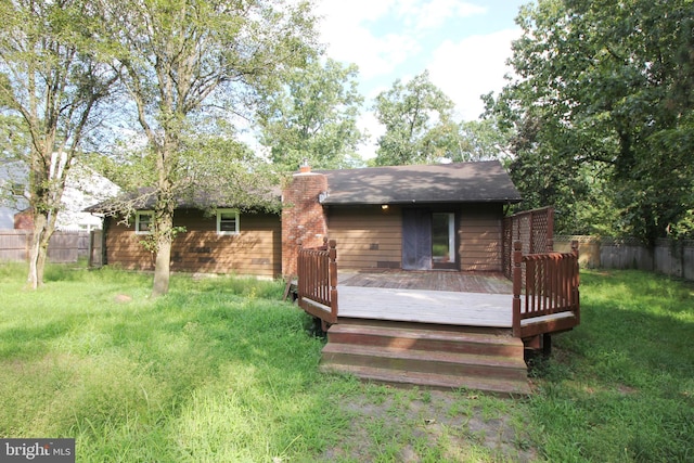 back of property featuring a lawn and a deck