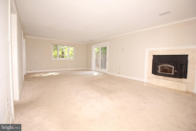 unfurnished living room with a tile fireplace, light colored carpet, and ornamental molding