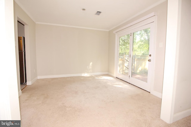 spare room featuring light carpet and crown molding