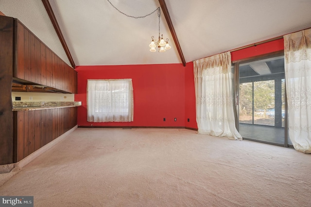 carpeted spare room with beam ceiling, high vaulted ceiling, and a chandelier