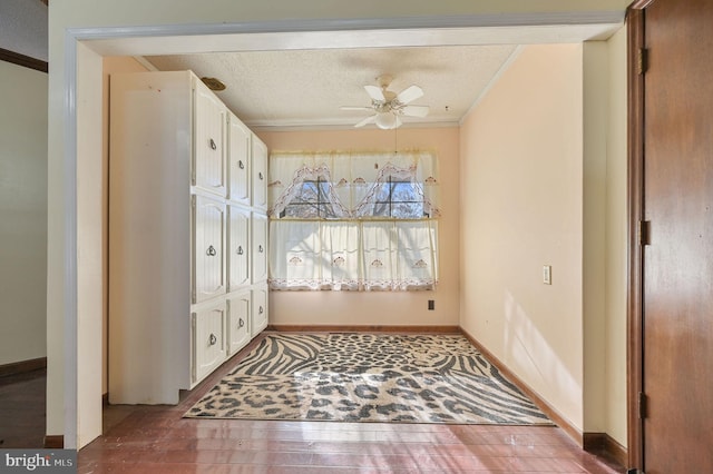 interior space with a textured ceiling, ceiling fan, and crown molding