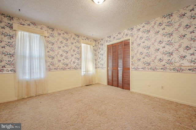 carpeted spare room featuring a textured ceiling