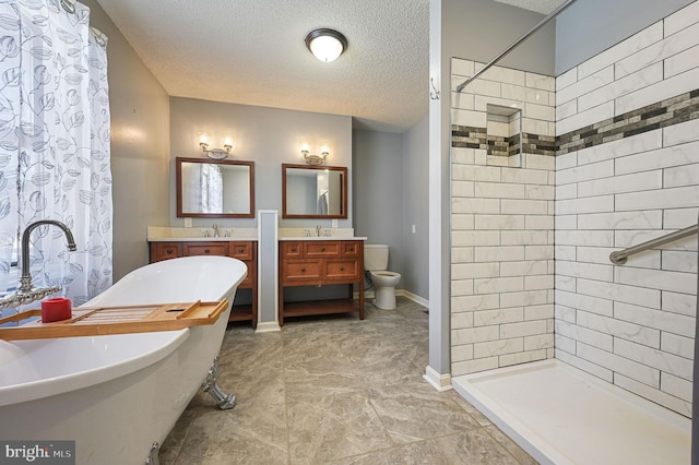 full bathroom featuring toilet, vanity, a textured ceiling, and separate shower and tub