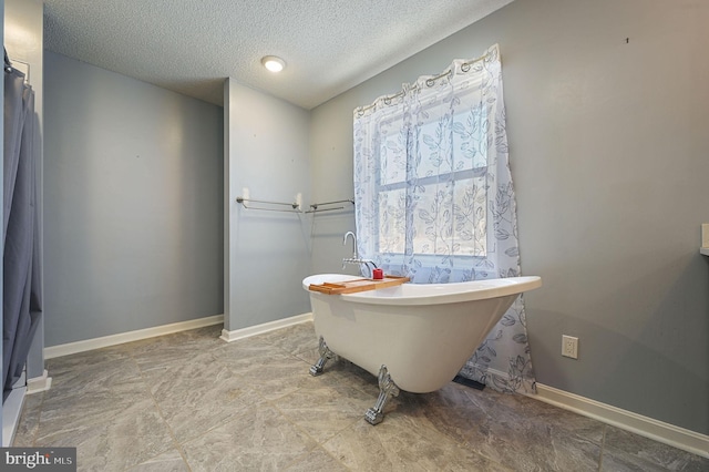 bathroom featuring a textured ceiling and a bath