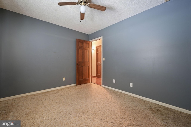 empty room featuring a textured ceiling, ceiling fan, and carpet