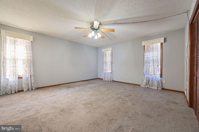 carpeted spare room with ceiling fan and a textured ceiling