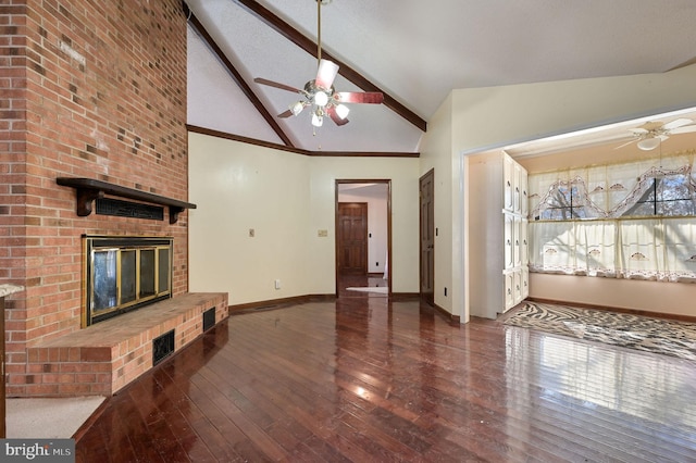 unfurnished living room with ceiling fan, a brick fireplace, vaulted ceiling with beams, and dark hardwood / wood-style floors