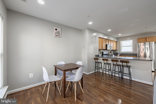 dining area featuring sink and dark hardwood / wood-style flooring