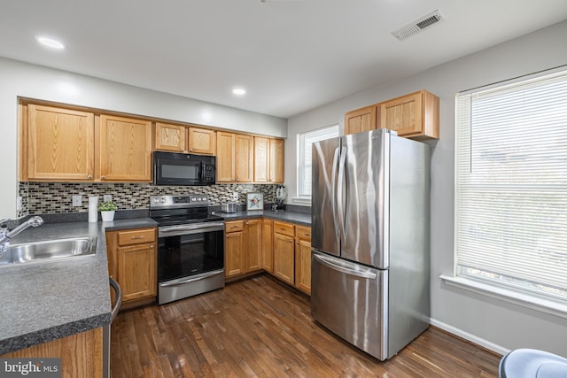 kitchen featuring appliances with stainless steel finishes, dark hardwood / wood-style flooring, sink, and decorative backsplash