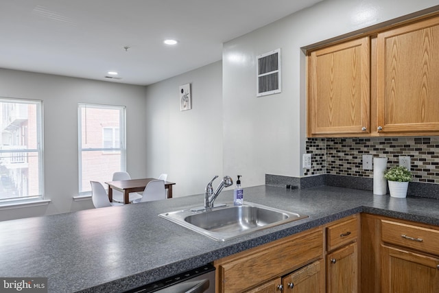 kitchen featuring dishwasher, sink, and backsplash