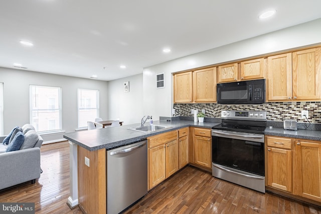 kitchen with sink, dark hardwood / wood-style flooring, kitchen peninsula, stainless steel appliances, and decorative backsplash