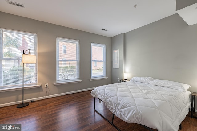 bedroom with dark wood-type flooring and multiple windows