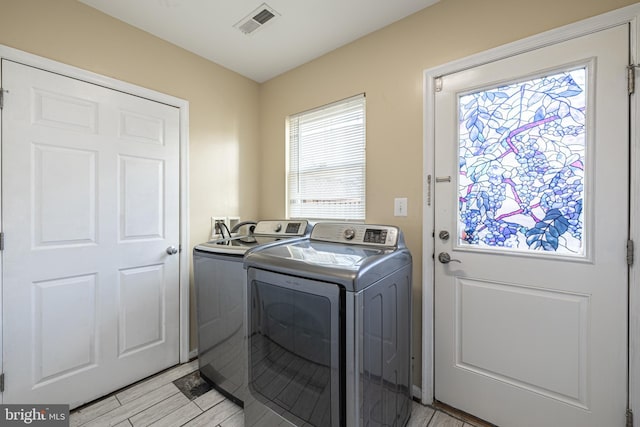 clothes washing area with washing machine and dryer