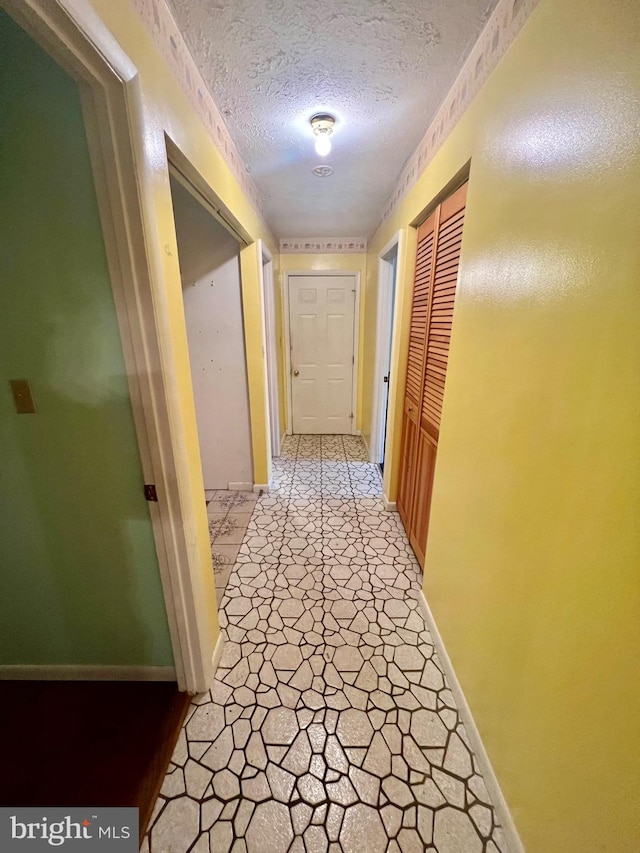 hall featuring a textured ceiling