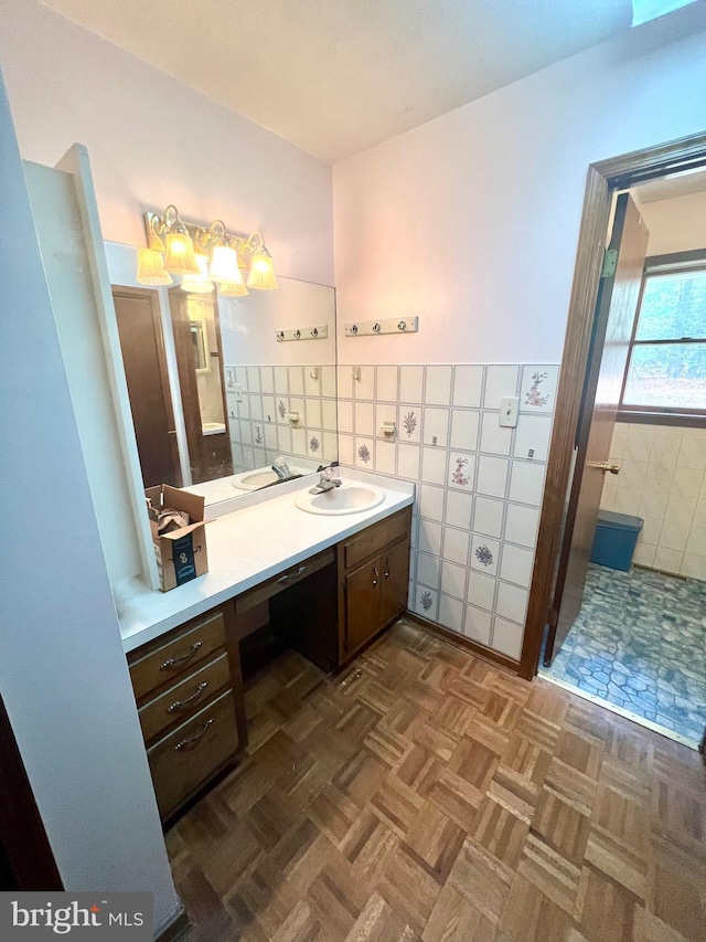 bathroom featuring vanity, parquet flooring, and tile walls