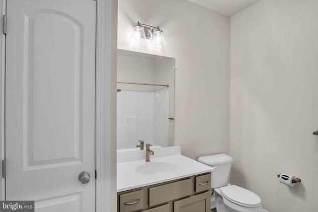 bathroom featuring vanity, toilet, and a shower