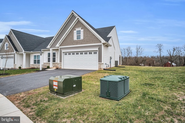 craftsman-style house featuring a garage, a front lawn, and central air condition unit