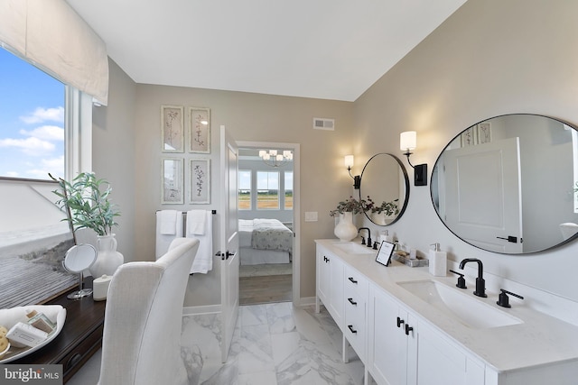 bathroom with a notable chandelier and vanity