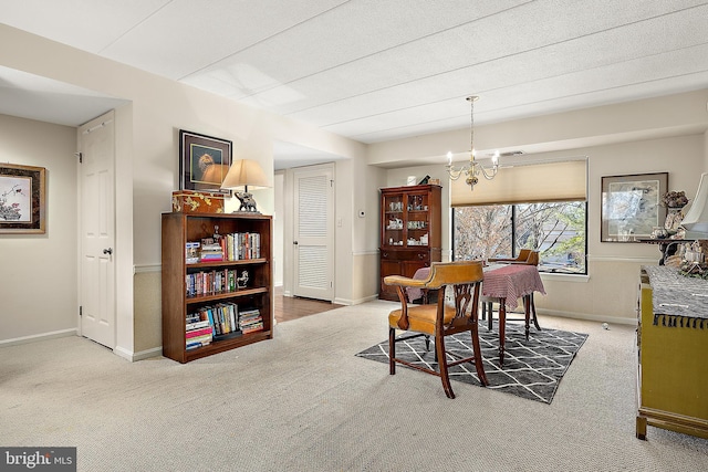 dining space with carpet floors and an inviting chandelier