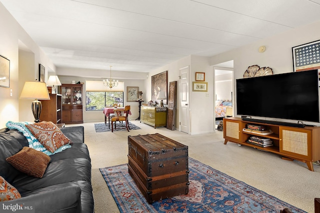 living room with light colored carpet and an inviting chandelier